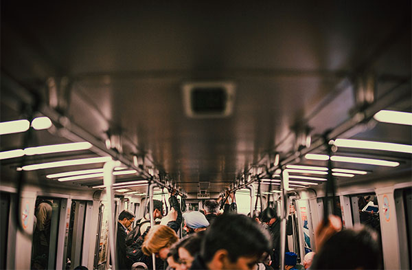 A view of the ceiling and tops of heads of riders on a BART train. (Unsplash/Corey Agopian)