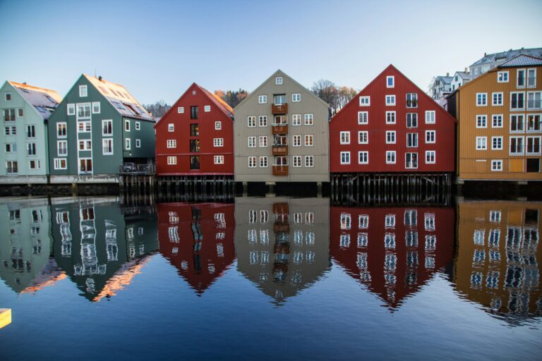 A row of Norwegian buildings reflecting on water (Unsplash/Simon Williams)